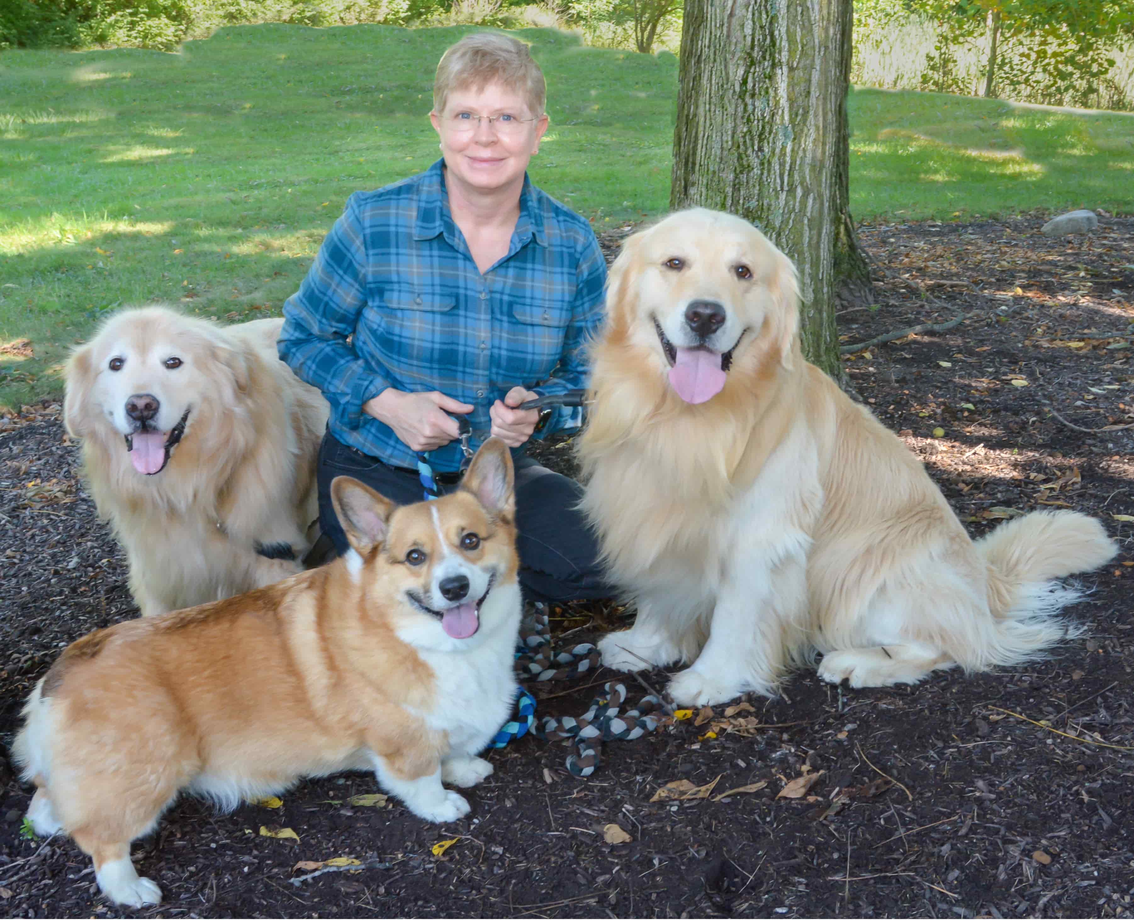 Dr. Christine Kelley outdoors with her Golden Retrievers